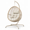 Sillón colgante de ratán sintético con cojines beige y estructura de acero